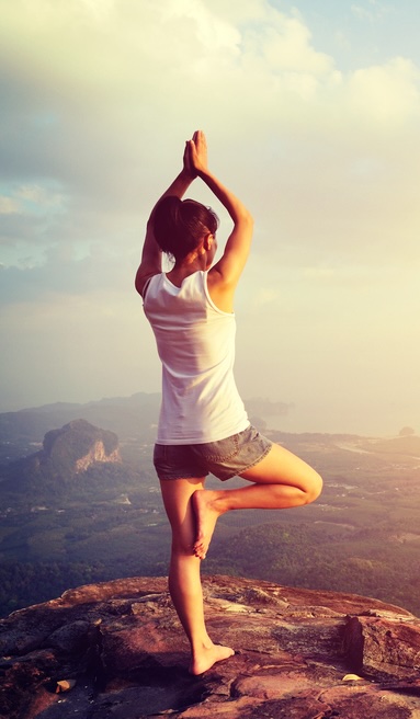 Personne en posture de yoga dans un paysage suisse, démontrant les bienfaits du yoga pour la santé physique et mentale.